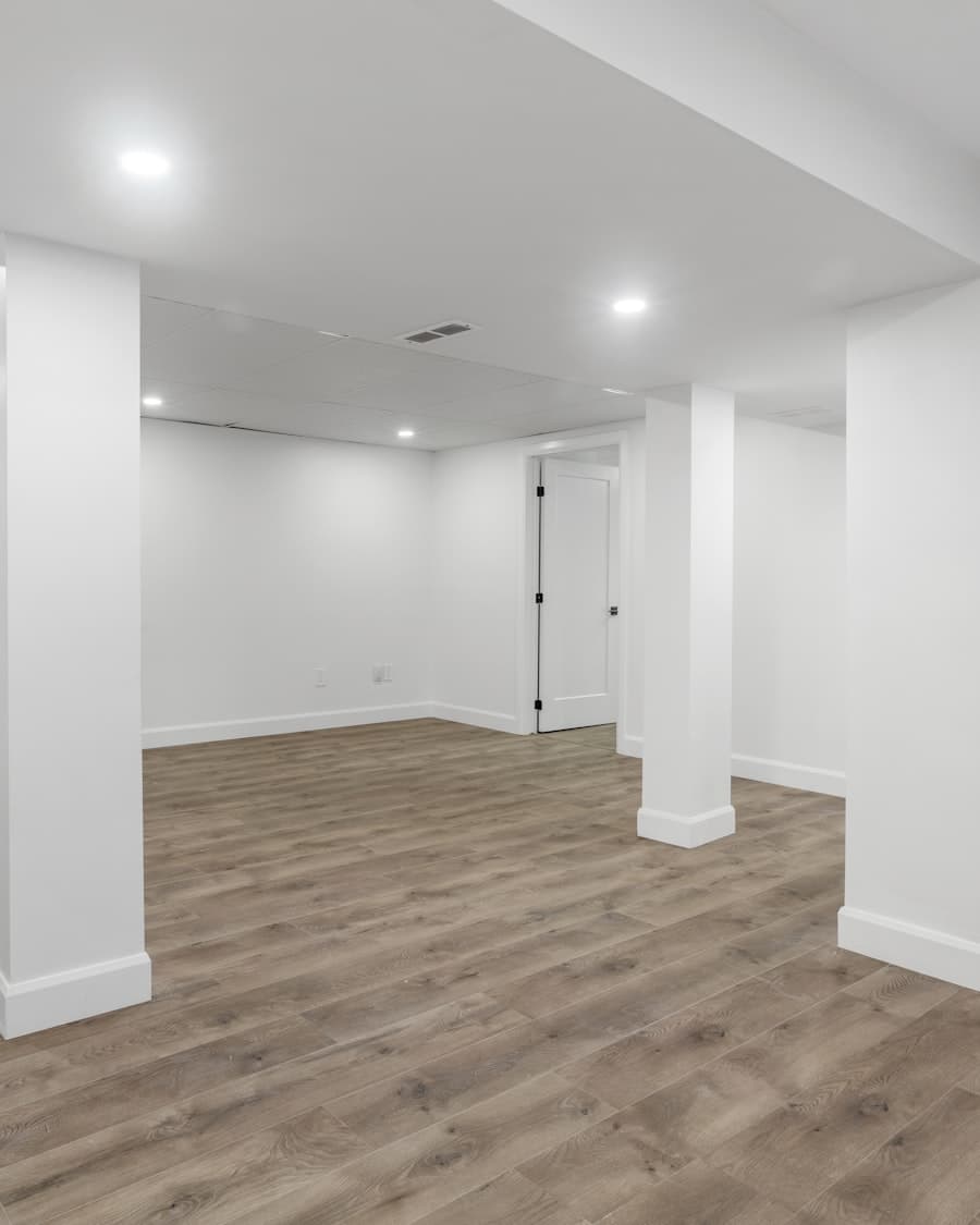 Newly finished basement with recessed lighting and wood-look flooring