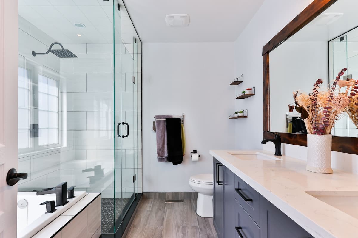 Remodelled bathroom with a glass subway-tiled shower and dark wood vanity